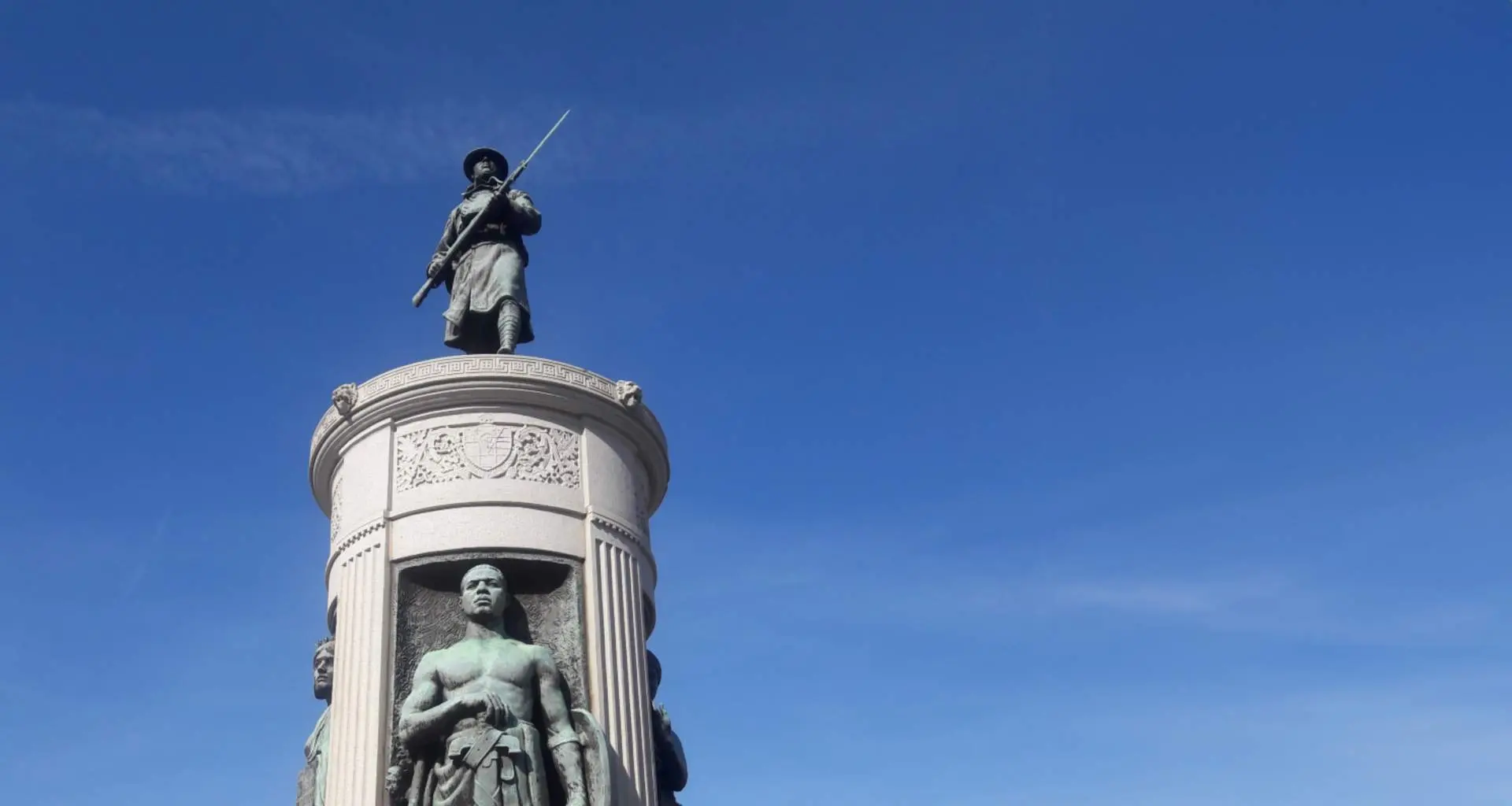 Una estatua de bronce de un soldado de la Primera Guerra Mundial adopta un zócalo de granito.