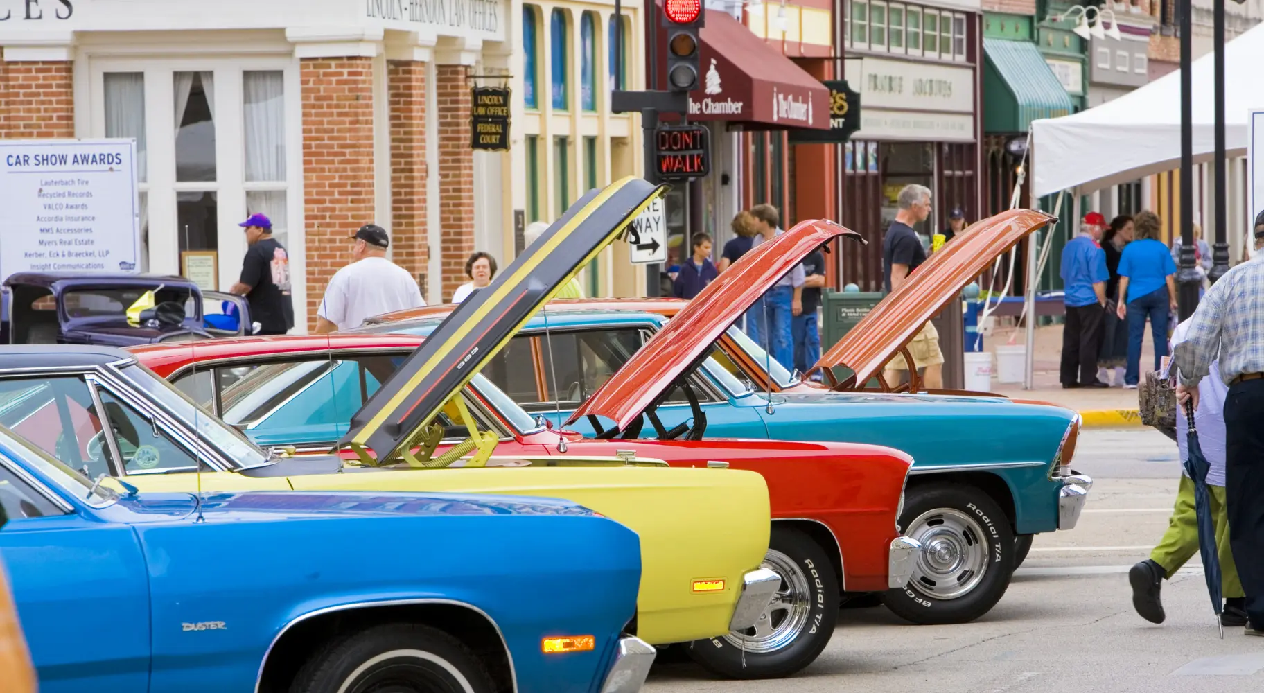 Coches clásicos en un salón automóvil con el capó abierto