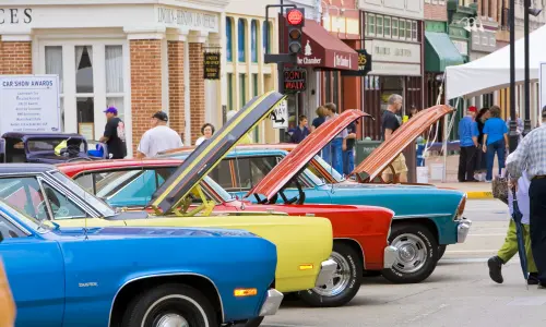 Coches clásicos en un salón automóvil con el capó abierto