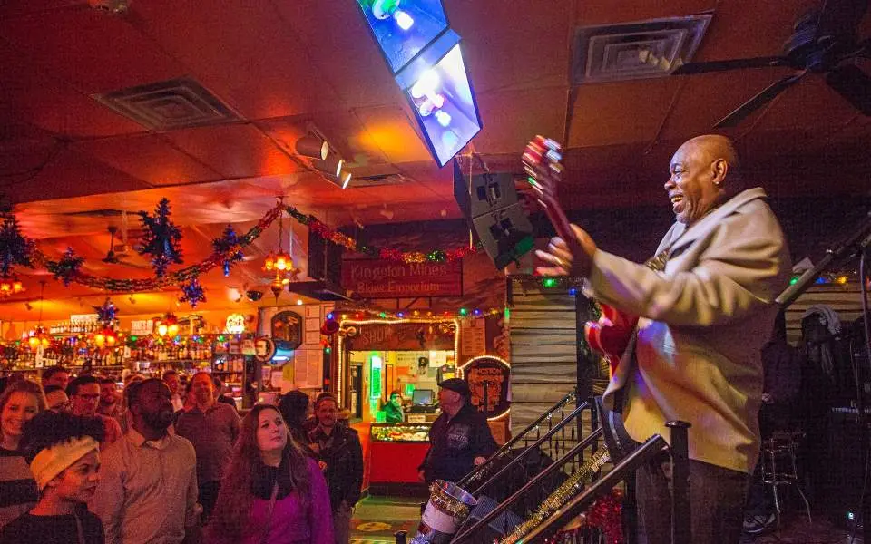 Un hombre tocando la guitarra en un bar