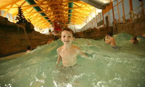Niño sonriendo en una piscina de olas.