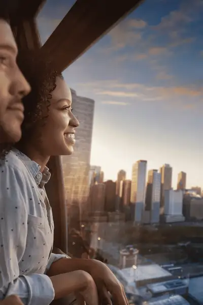 Pareja en el interior de la Noria Centenaria durante la puesta de sol con vistas a la ciudad.