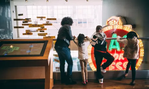Niños y adultos mirando desde una barandilla 