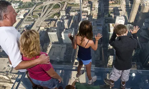 Gente mirando al edificio de abajo