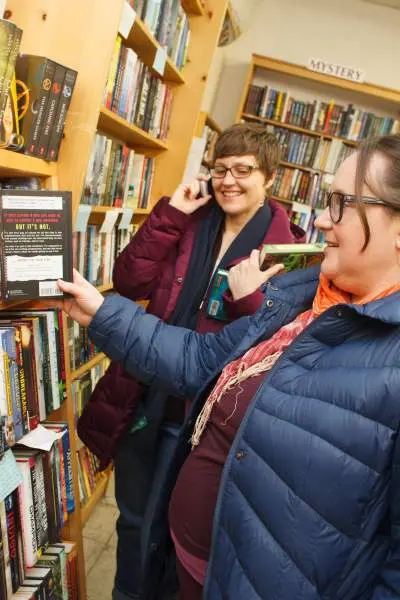 Mujeres en una librería mirando una estantería de libros
