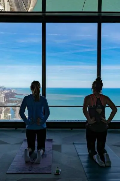 Cuatro personas arrodilladas sobre esterillas de yoga mirando la costa Chicago
