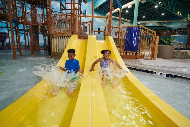 Niños deslizándose por el tobogán del parque acuático Great Wolf Lodge.