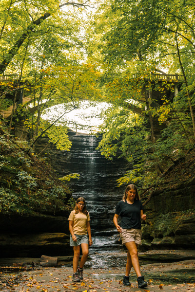 Dos niñas caminan frente a una cascada en el Parque Estatal Matthiessen