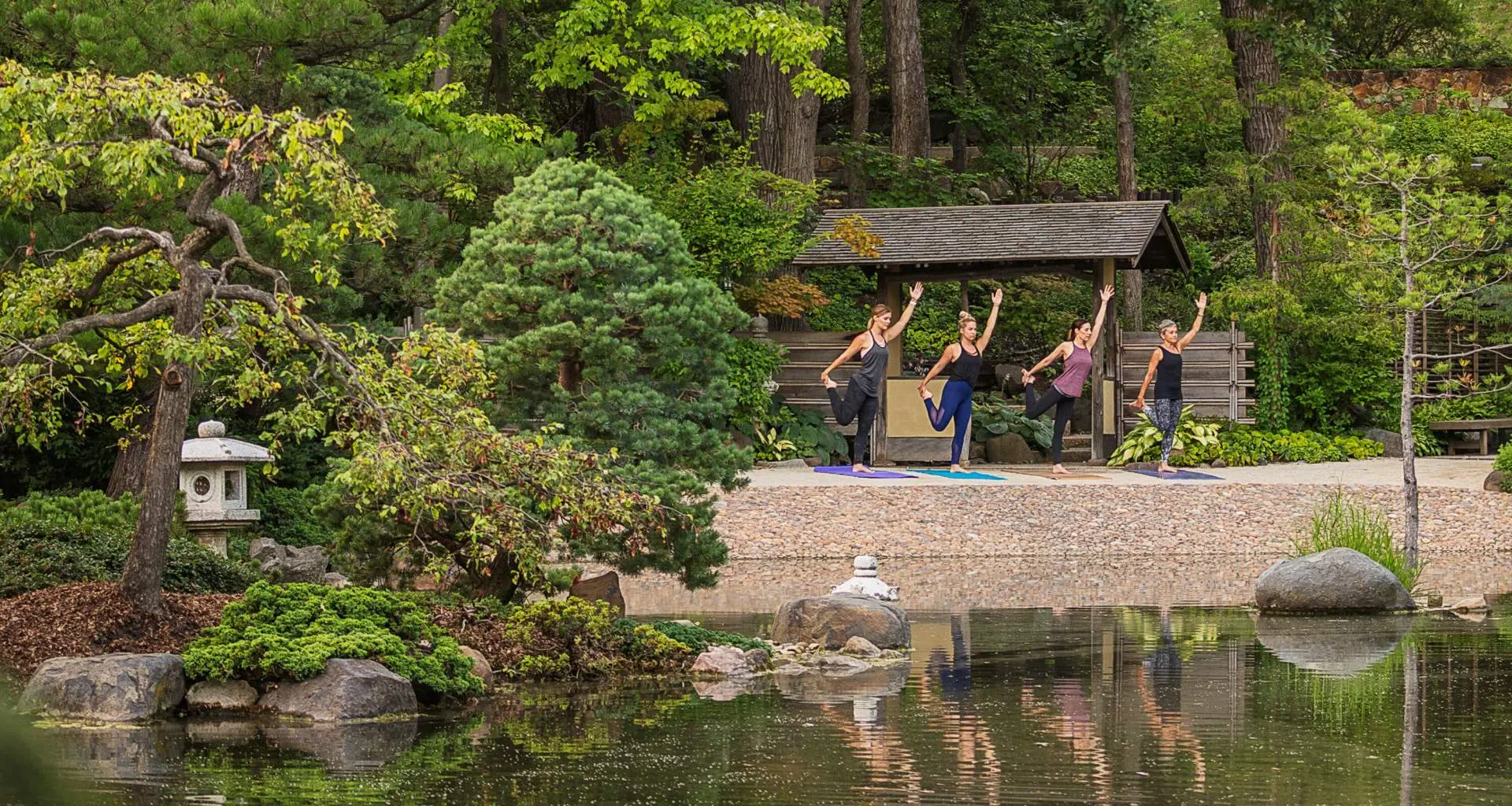 Gente haciendo yoga frente al lago