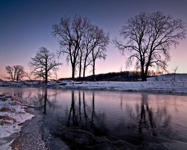 Las orillas nevadas del arroyo Nippersink al atardecer, en Glacial Park, condado de McHenry.