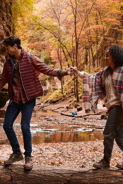 Pareja haciendo senderismo por el bosque durante el otoño.