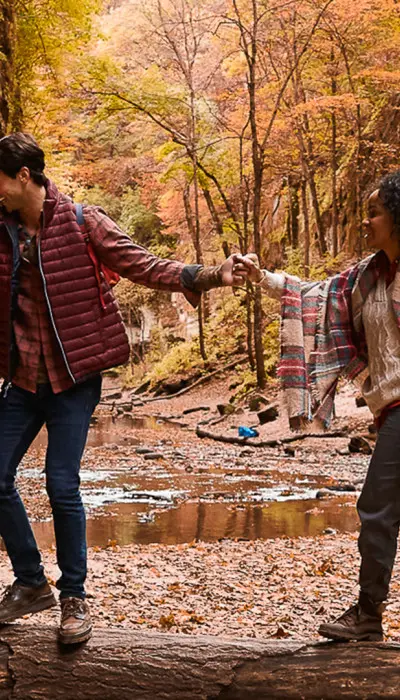 Pareja haciendo senderismo por el bosque durante el otoño.