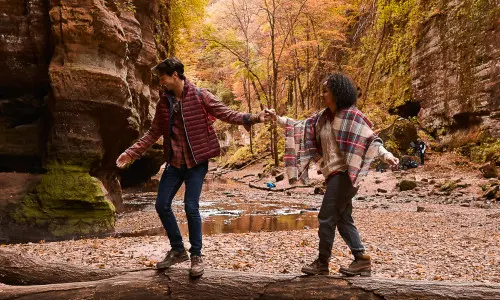 Pareja haciendo senderismo por el bosque durante el otoño.