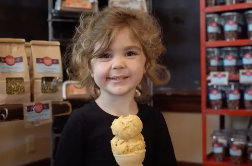Un niño pequeño disfruta de un helado en cucurucho. 