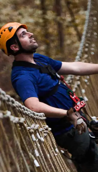 Escaladores con arneses cruzando un puente.