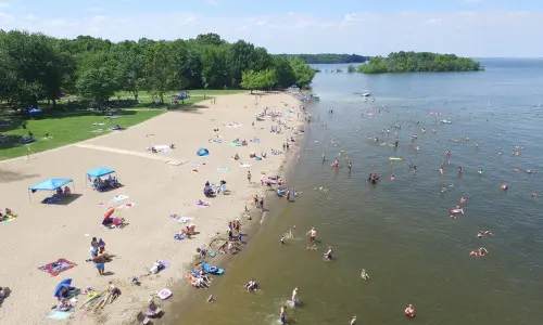 Una vista aérea de una playa con gente disfrutando del sol, la arena y el agua