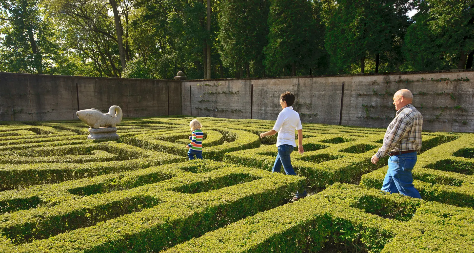 Gente caminando por un jardín laberíntico