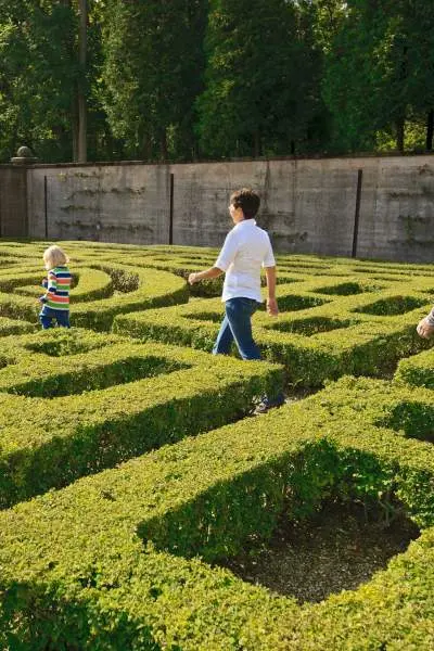 Gente caminando por un jardín laberíntico