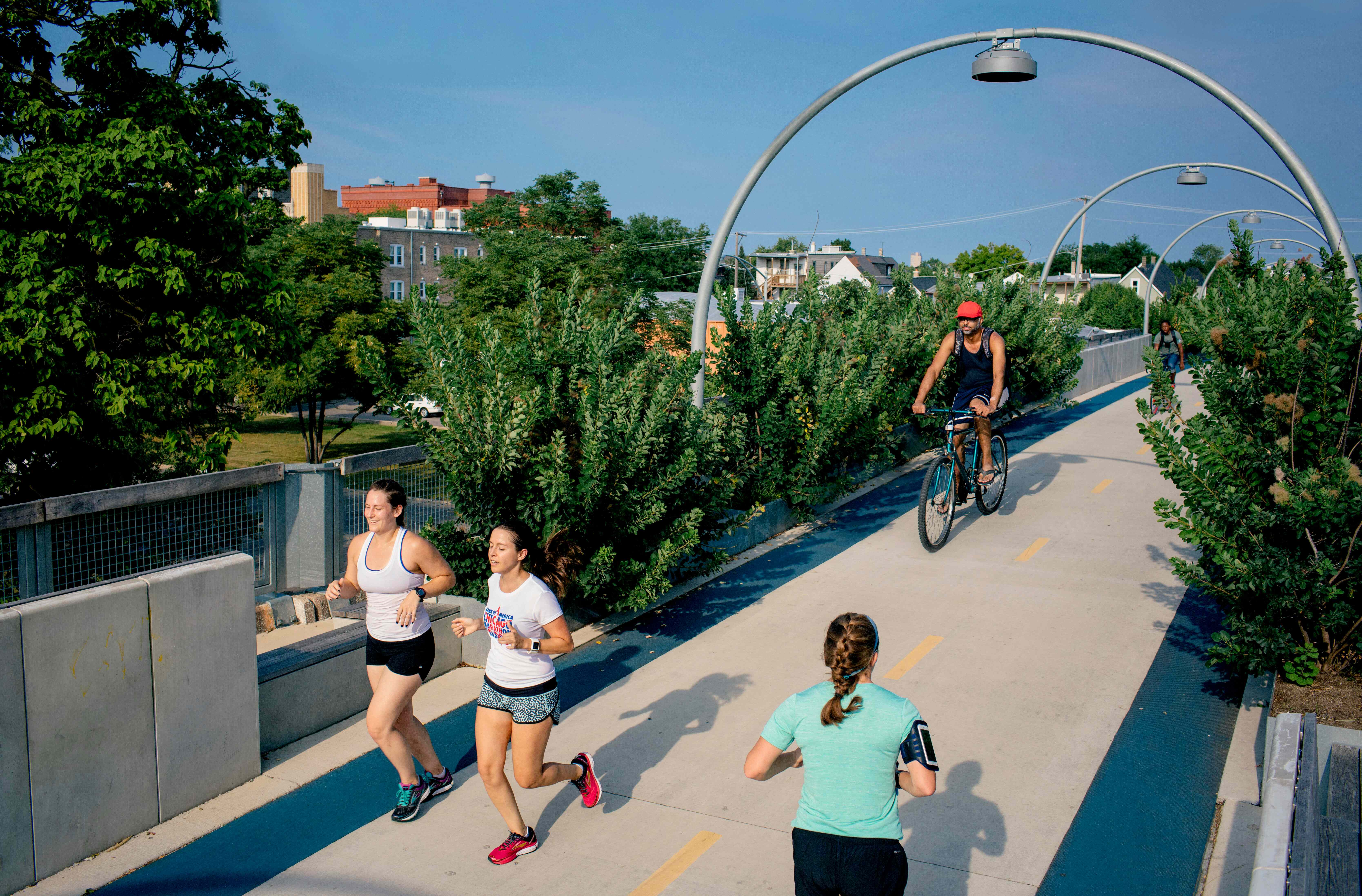 Gente corriendo y en bici por el puente para bicicletas 