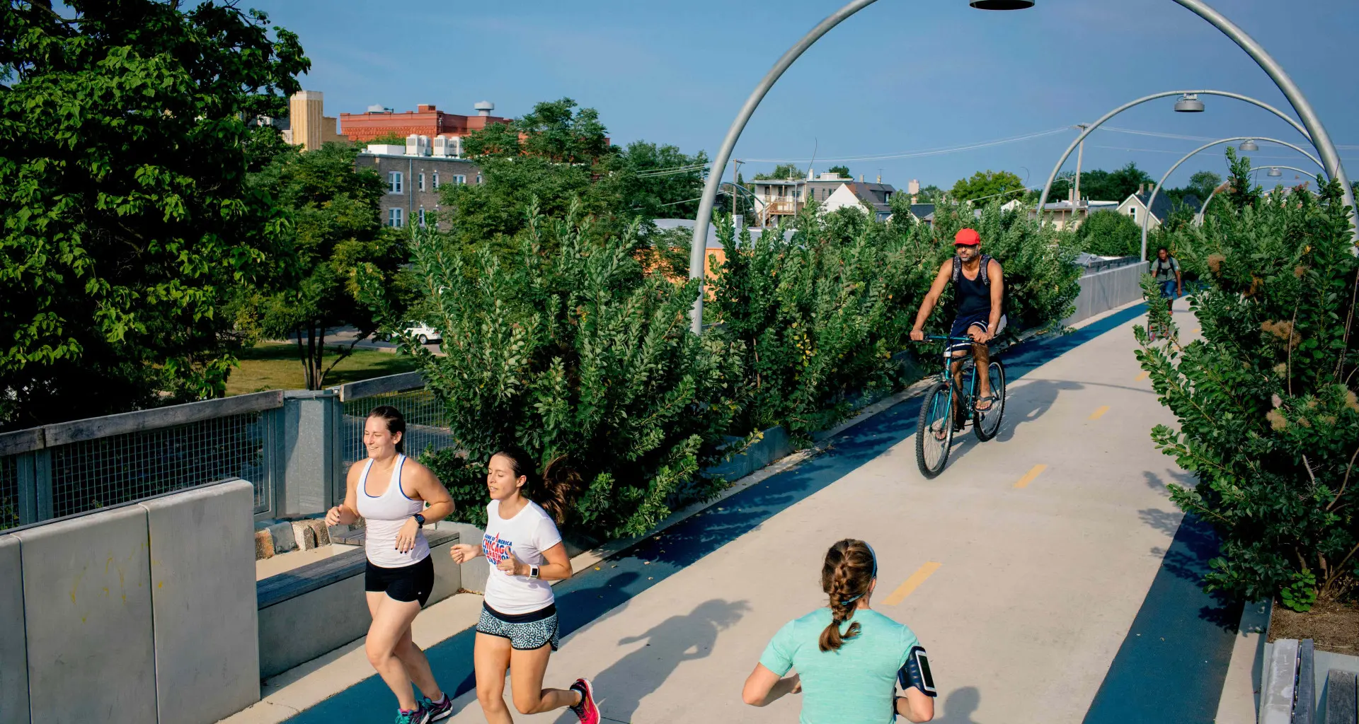 Gente corriendo y andando en bici por el puente para bicicletas 