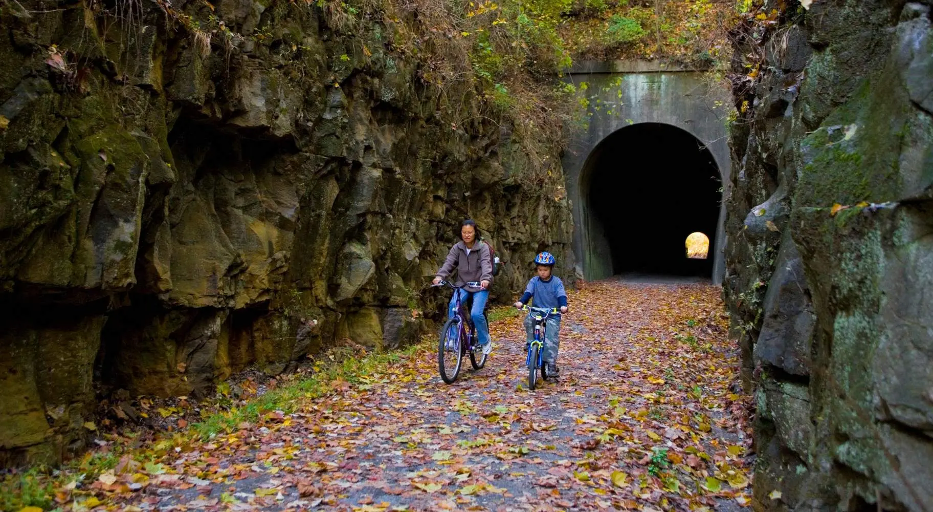 Dos personas en bicicleta por un túnel