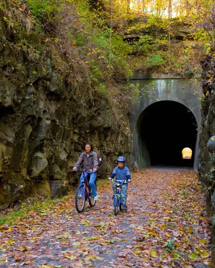 Dos personas en bicicleta por un túnel