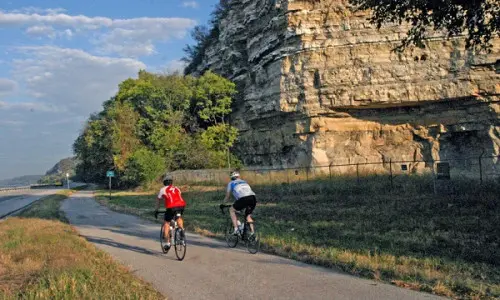 Dos ciclistas en bicicleta por una pista de carretera
