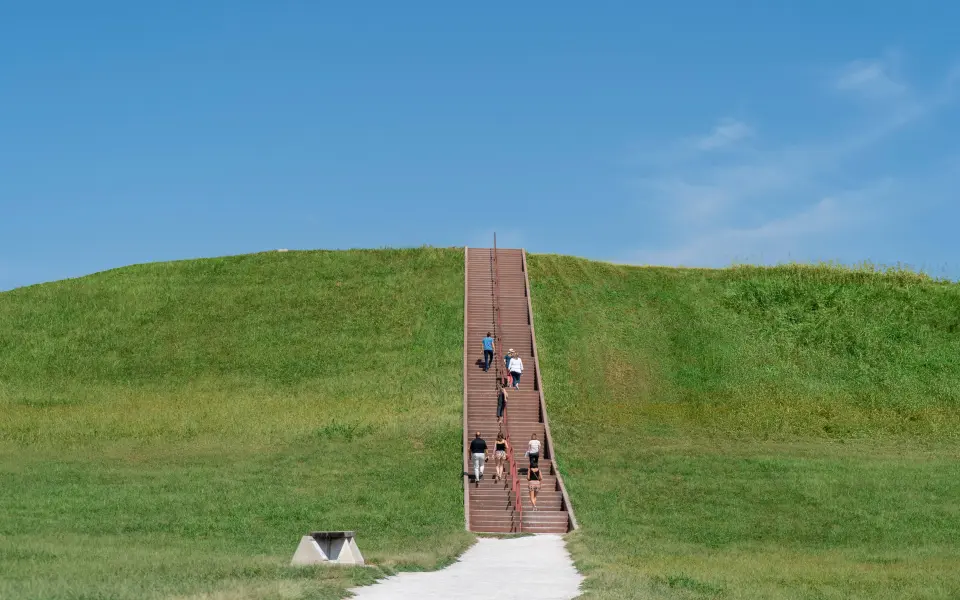 La gente sube las escaleras hasta la cima de Cahokia Mounds