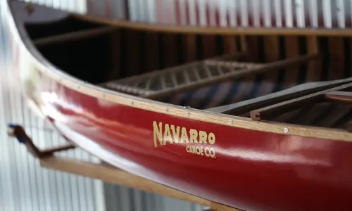Una canoa roja con el logotipo de Navarro Canoe.