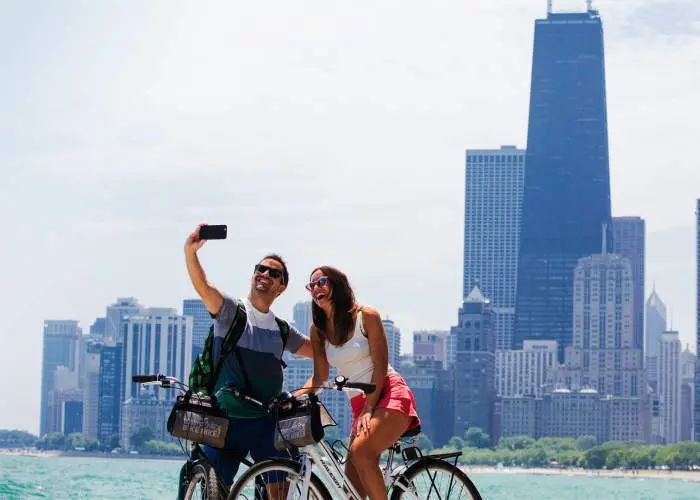 Una pareja monta en bicicleta y se hace una foto a orillas del lago de Chicago