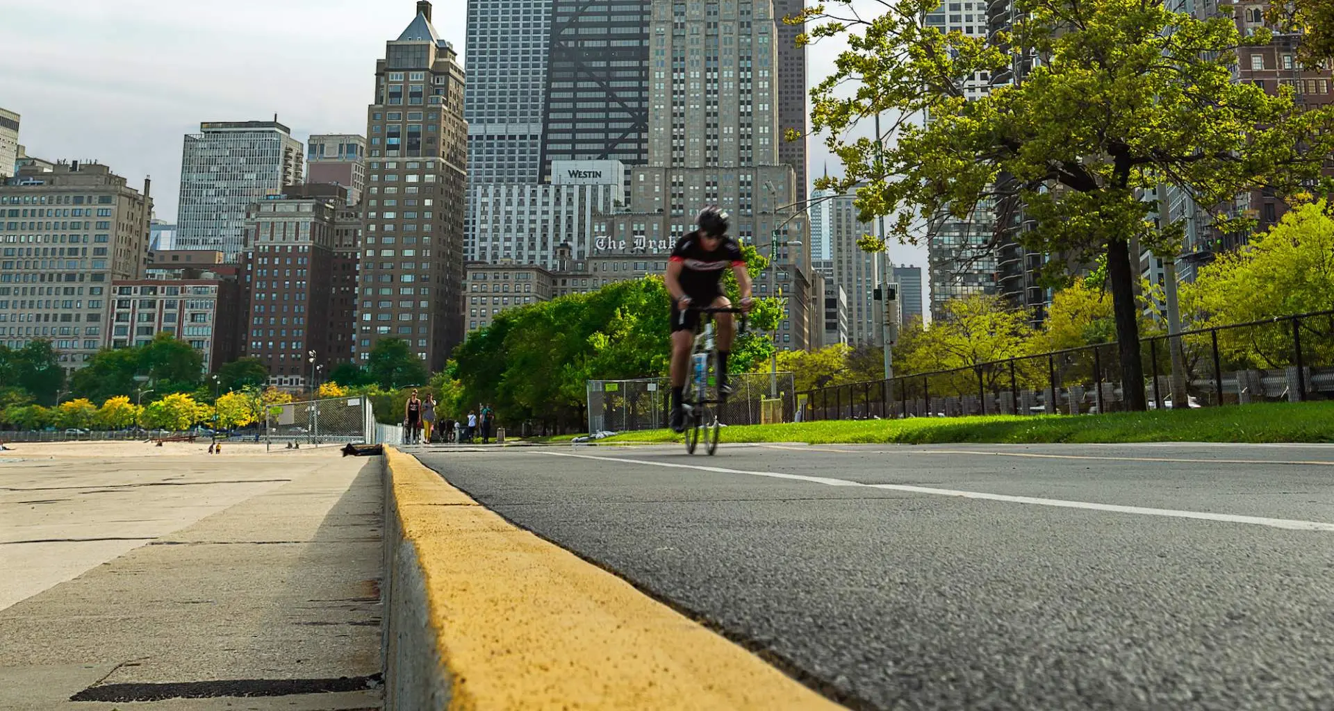 Ciclista de carretera en el carril bici frente al lago en Chicago con la ciudad de fondo