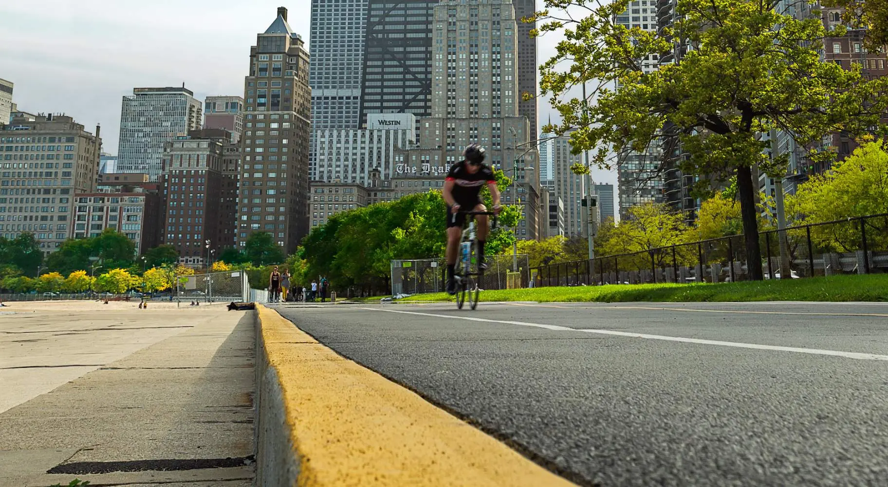 Ciclista de carretera en el carril bici frente al lago en Chicago con la ciudad de fondo