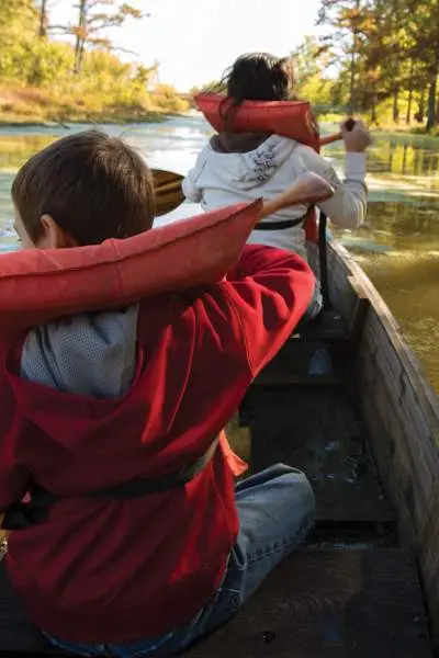 Una familia con chaleco salvavidas en canoa por un río