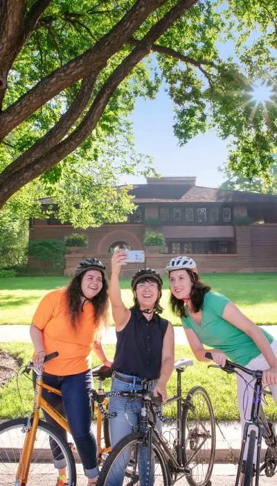 Gente en bici posando para una foto con una casa al fondo