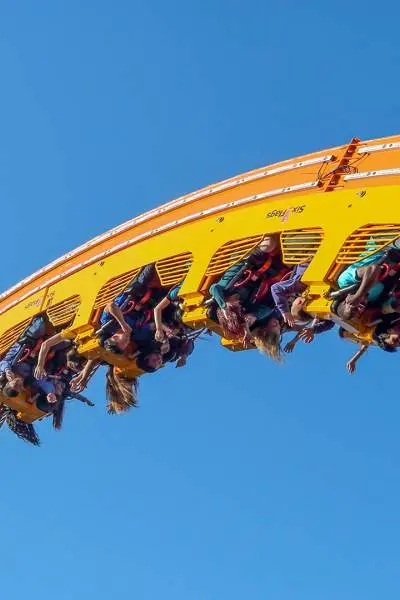 Grupo de personas montadas en la montaña rusa en pleno vuelo. 