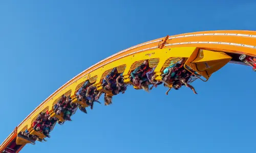 Grupo de personas montadas en la montaña rusa en pleno vuelo. 