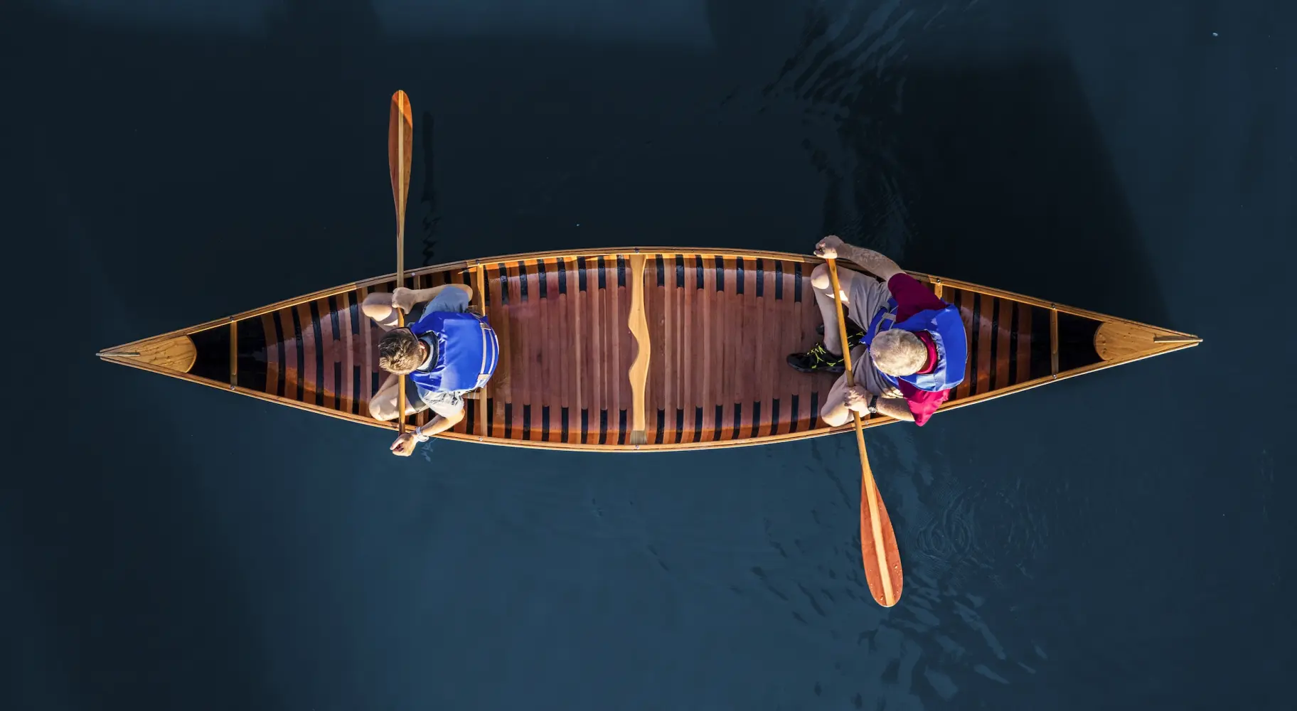 Foto aérea de dos personas en una canoa sobre aguas azules