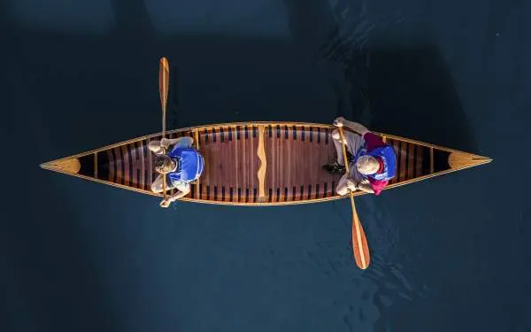 Foto aérea de dos personas en una canoa sobre aguas azules