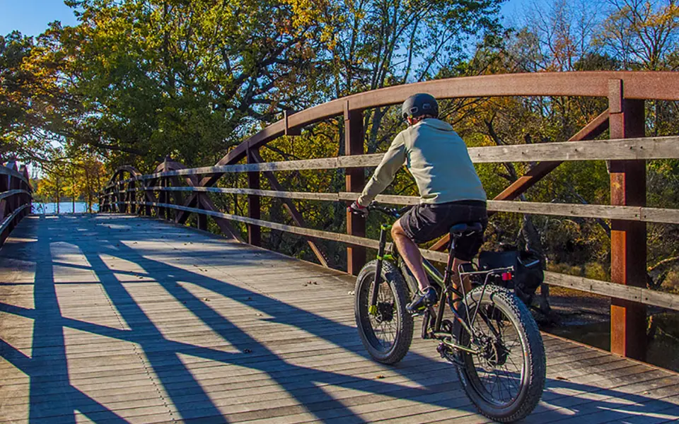 Persona en bicicleta sobre el puente en Independence Grove Forest Preserve 