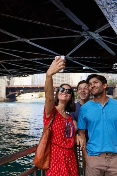 Gente posando para una foto junto al río bajo el puente 