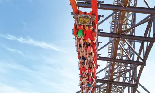 Una montaña rusa roja llena de gente