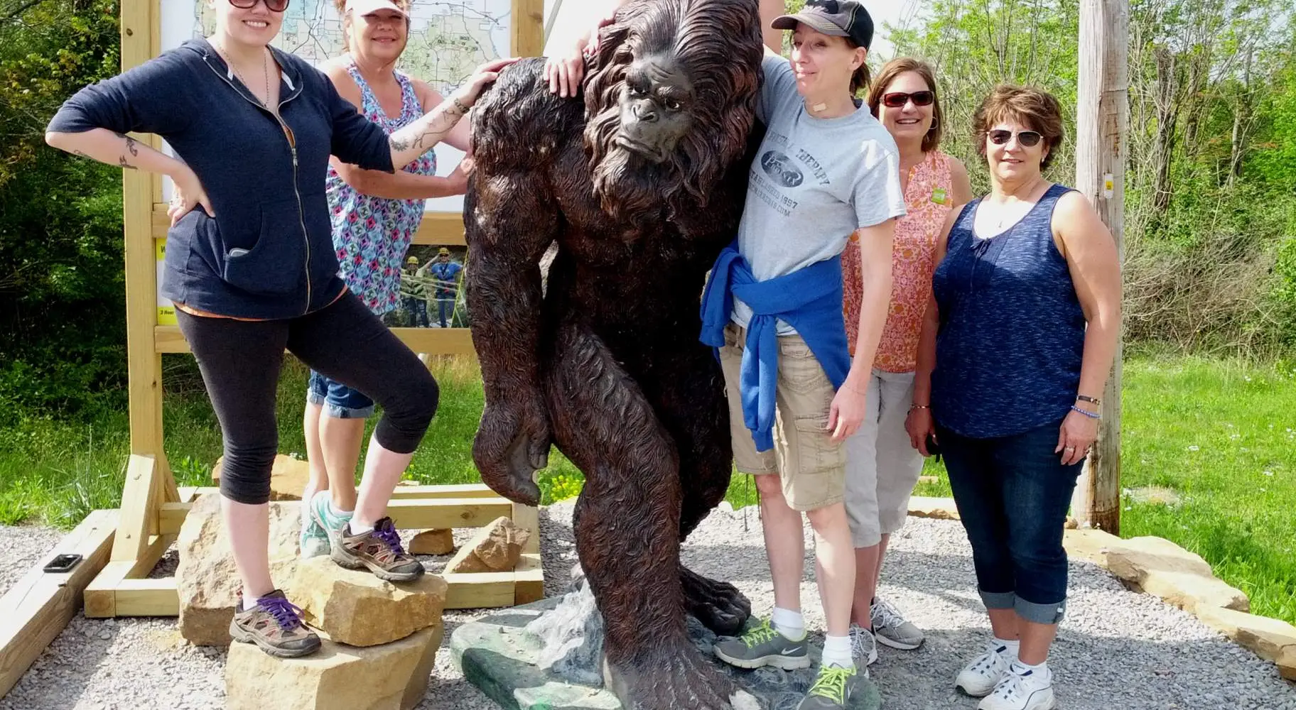 Un grupo de seis mujeres posa con la estatua de un sasquatch llamado Sassy