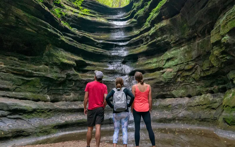Tres personas mirando una cascada