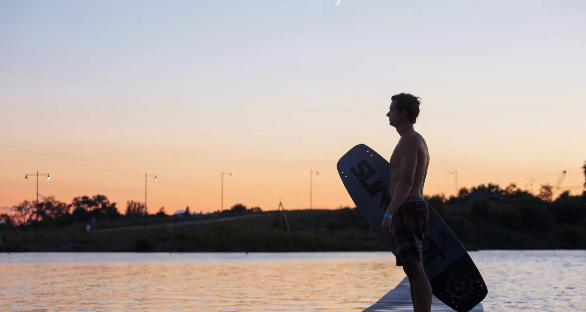 Un wakeboarder junto al parque Quarry Cable al atardecer