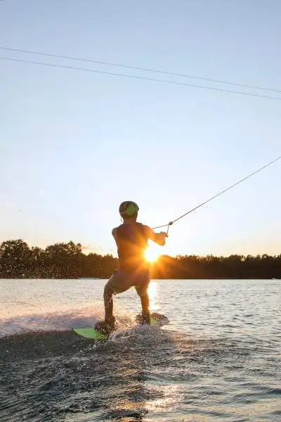 Una persona practicando wakeboarding al atardecer 