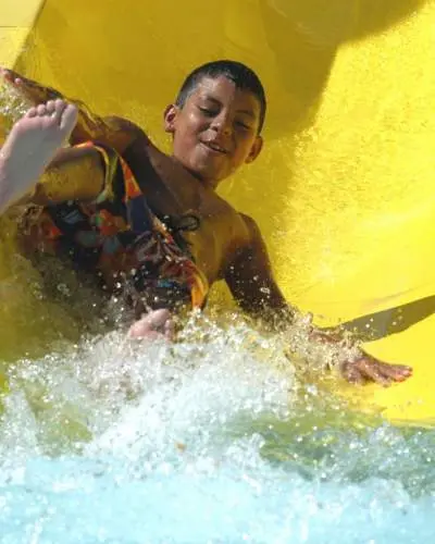 Niño bajando tobogán amarillo Great America Hurricane Harbor