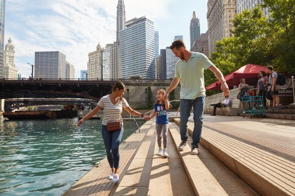 Familia despertando junto a un río con la ciudad de fondo