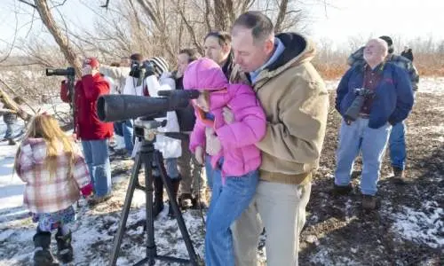 Gente mirando a través del objetivo de una cámara grande