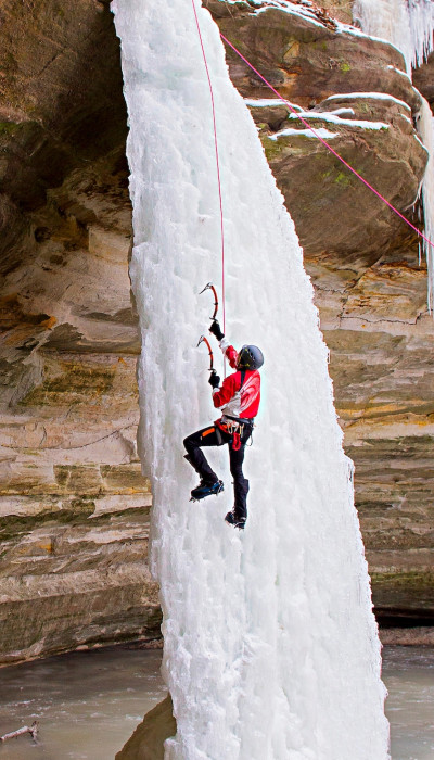 Persona escalando una cascada de hielo