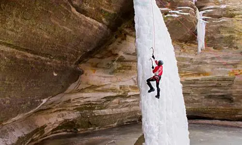 Persona escalando una cascada de hielo